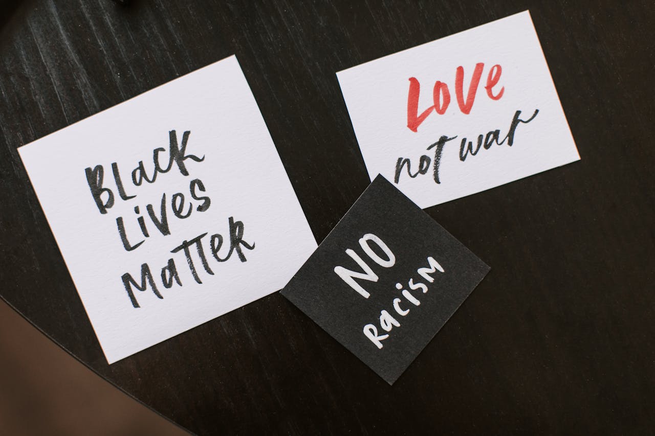 Collection of handwritten signs promoting equality and peace: Black Lives Matter, No Racism, Love Not War.